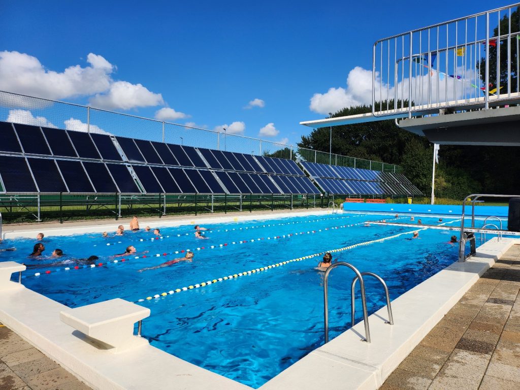 overzicht hoofdbad van het streekbad met zonnepanelen op de achtergrond